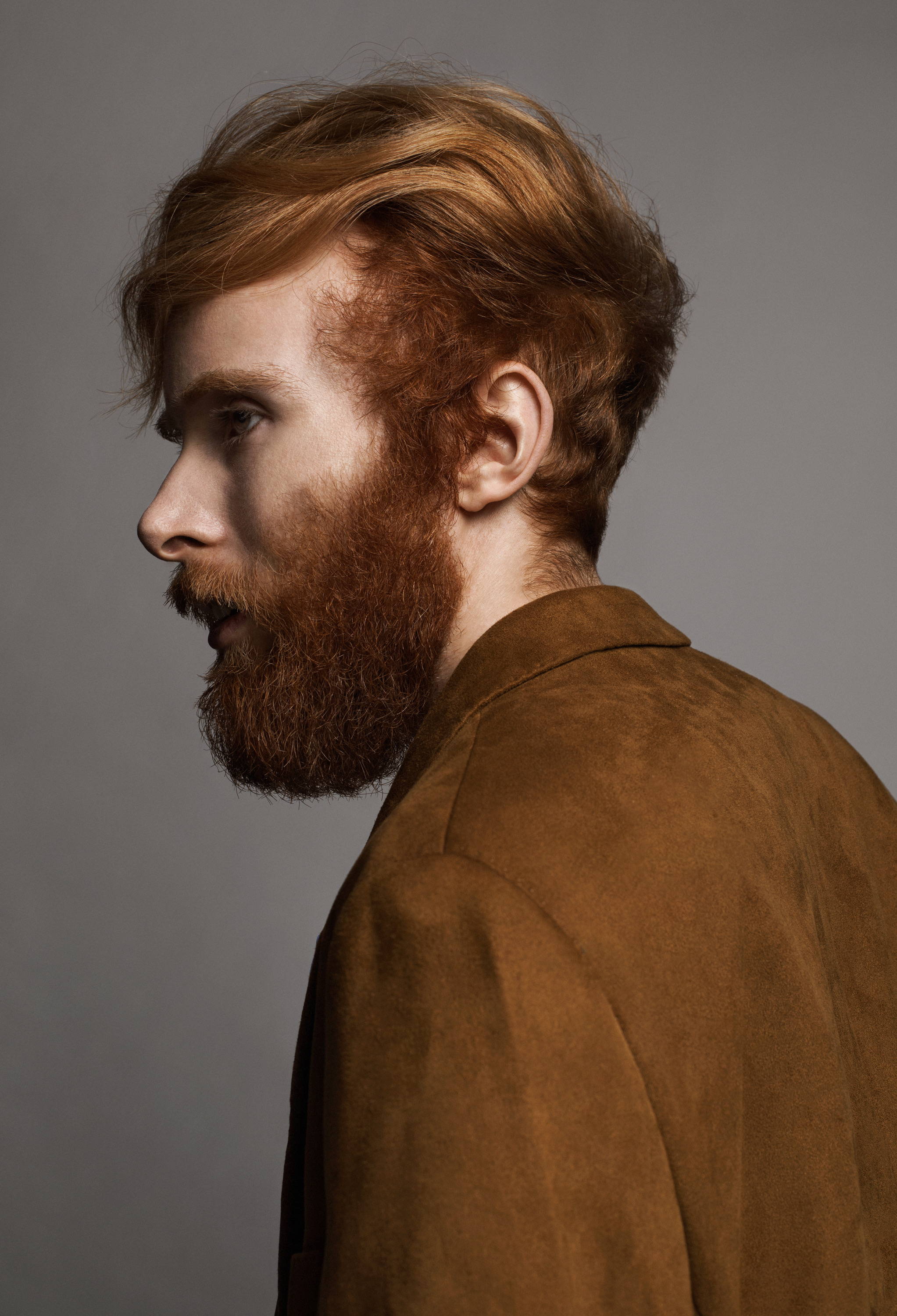 Josh Cruddas standing with this face to the side in a brown jacket