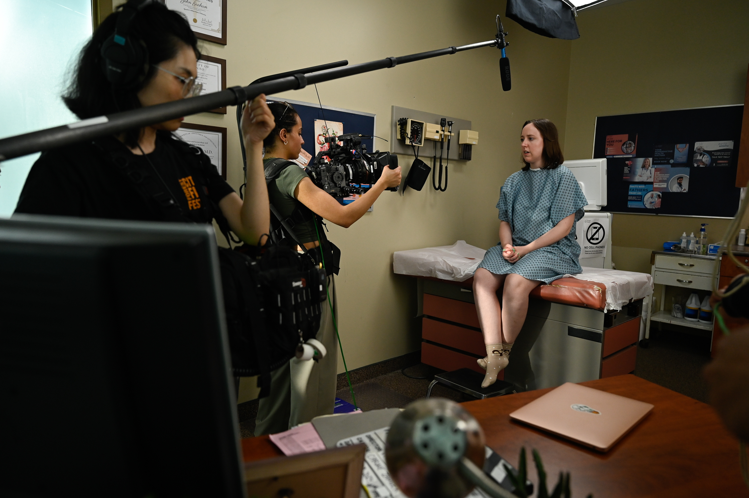 Photo of Sarah (Alice) on the bed in the set being filmed by Carine and sound being captured by a boom microphone.